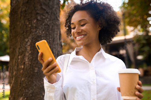 A curly-haired girl talking on the phone and looking pleased photo