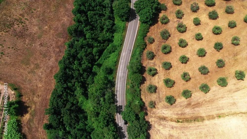 Aerial Top view of Tuscan countryside shot with drone at summer time. Top view of amazing country in sunny weather, arid wheat fields,green trees,olive trees  photo