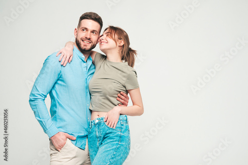 Smiling beautiful woman and her handsome boyfriend. Happy cheerful family having tender moments on grey background in studio.Pure cheerful models hugging.Embracing each other