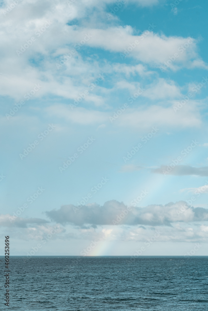 blue sky with clouds and rainbow