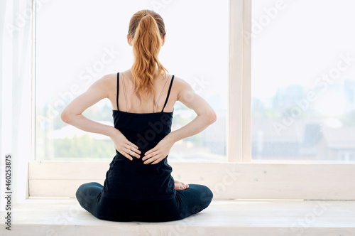 woman doing yoga near the window energy fitness exercise lifestyle