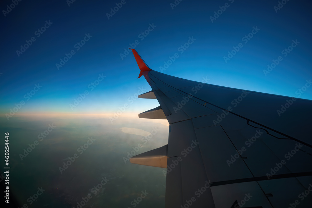 View of the wing of the plane through the window, sunset, clouds. Flight and tourism concept. Turkey View of the wing of the plane through the window, sunset, clouds. Flight and tourism concept. Turkey