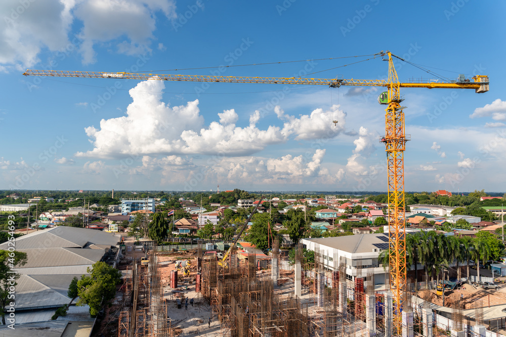 A crane in large construction site, Crane working on a building complex with cloud and blue sky. A crane in large construction site, Crane working on a building complex with cloud and blue sky.