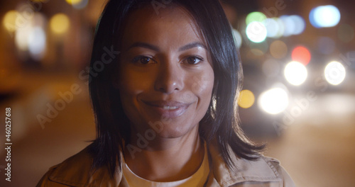 Beautiful mixed race woman posing outdoors on background with blurred lights © nimito