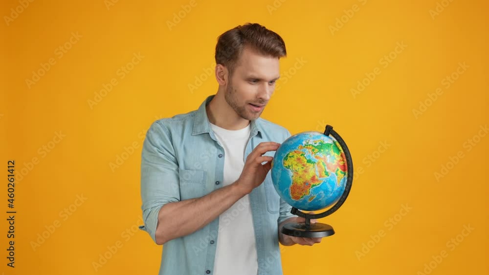 Puzzled confused guy hold globe search country direct finger Puzzled confused guy hold globe search country direct finger