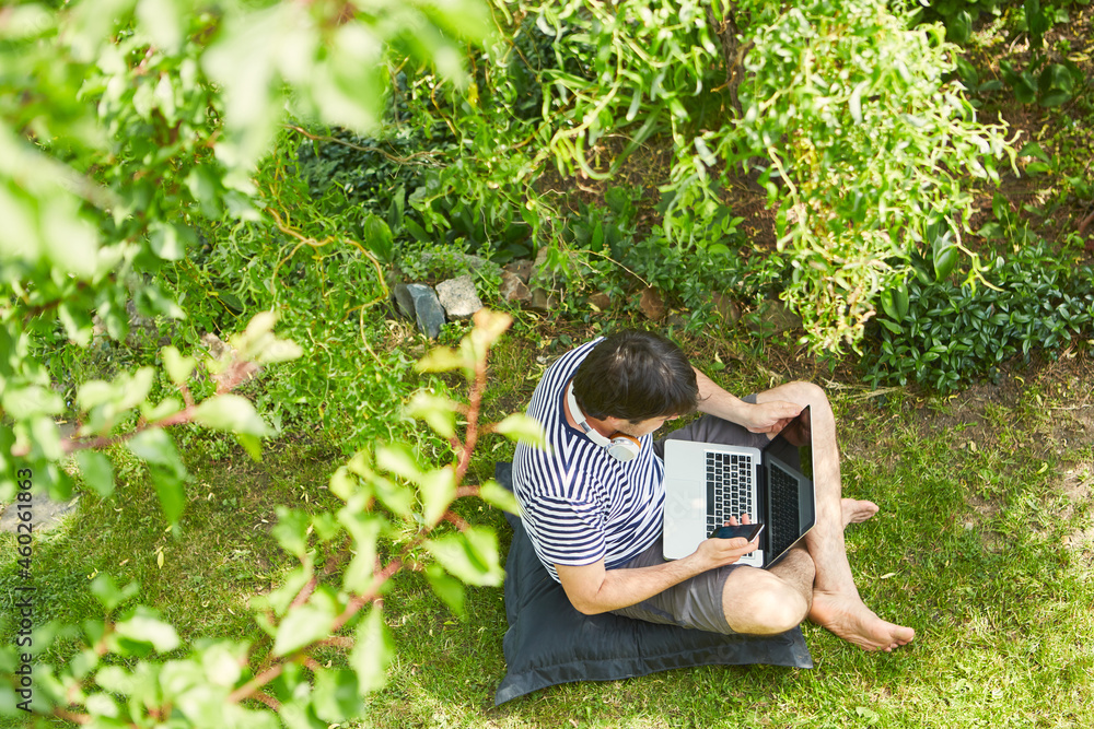 Mann im Garten im Sommer arbeitet am Laptop Stock Photo Adobe Stock