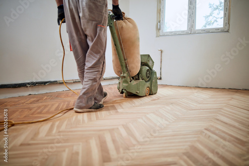 Quadro em tela Repairman restoring parquet with a sanding machine.