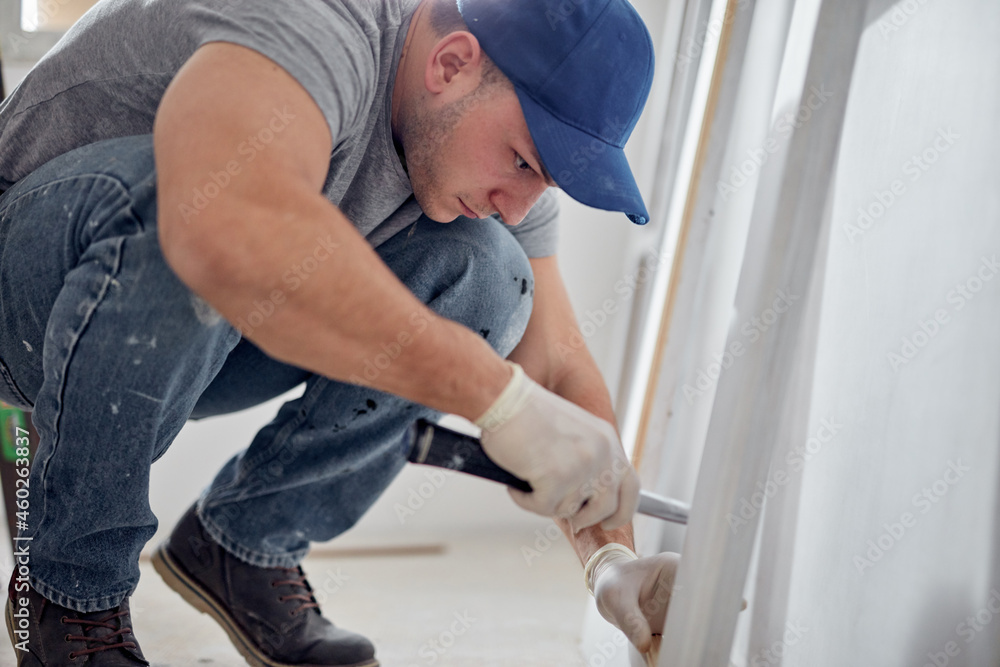 Fototapeta premium Young adult man working on a DIY budget renovation of his new home apartment.