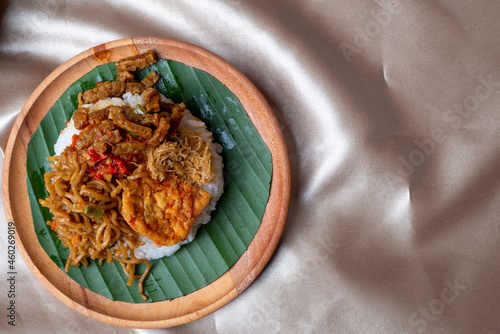 Nasi Campur, Indonesian Typical Food from East Java Province. Contain white rice, spicy tofu, tempeh, serundeng, and fried noodles