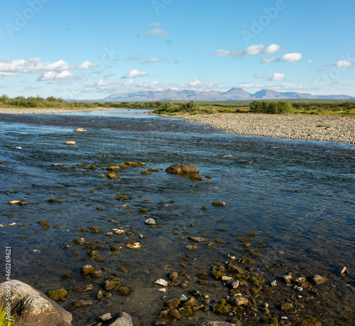 Summer river landscape with cloudy sky. Nature background, riverbank.