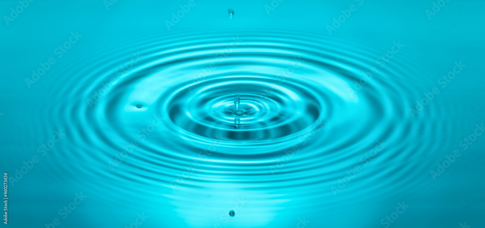 falling drops on the water surface, splash, ripples on the water, blue color falling drops on the water surface, splash, ripples on the water, blue color
