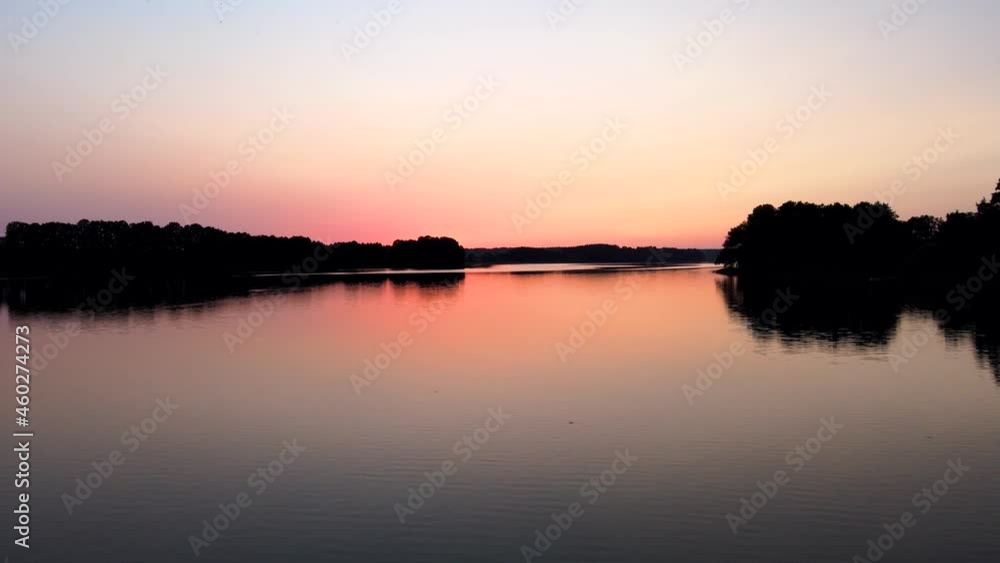 Beautiful Sunset of the Masurian Sea. Emerald green water surrounded by forests, autumn grass and passing clouds. Shoot with the drone Beautiful Sunset of the Masurian Sea. Emerald green water surrounded by forests, autumn grass and passing clouds. Shoot with the drone