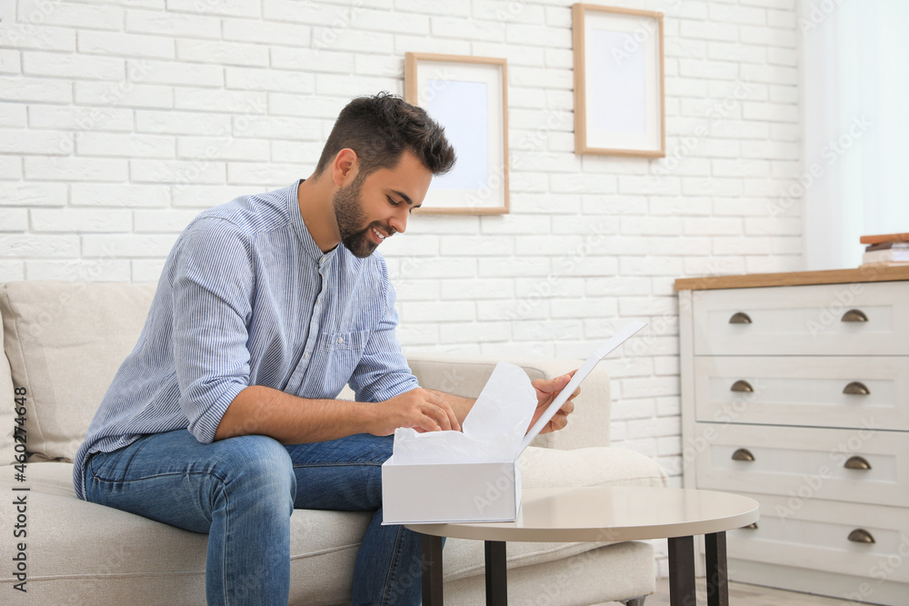 Man unpacking parcel at home. Online shopping Man unpacking parcel at home. Online shopping