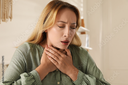 Young woman suffering from pain during breathing at home