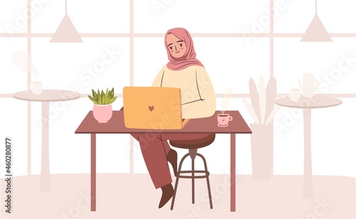 Woman in hijab working at cafe. Empowered business woman working on laptop. Muslim student with laptop in cafe