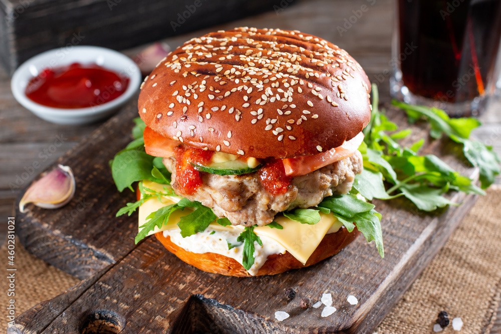 Homemade juicy burgers with beef, cheese and arugula on a table. American cuisine. Fast food Homemade juicy burgers with beef, cheese and arugula on a table. American cuisine. Fast food