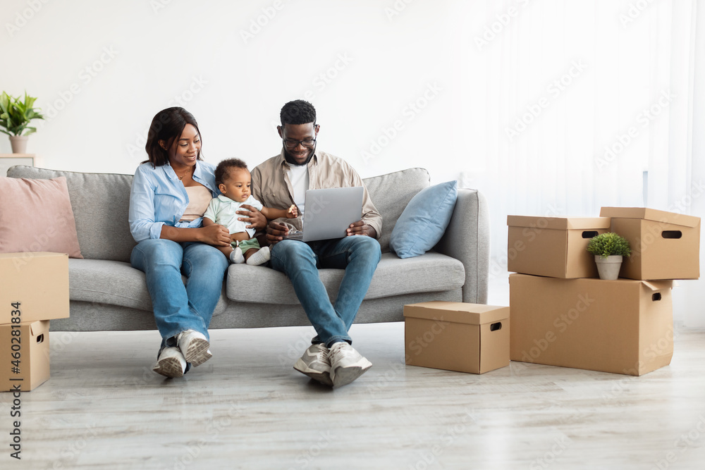 Happy man woman and kid using laptop after relocation Happy man woman and kid using laptop after relocation