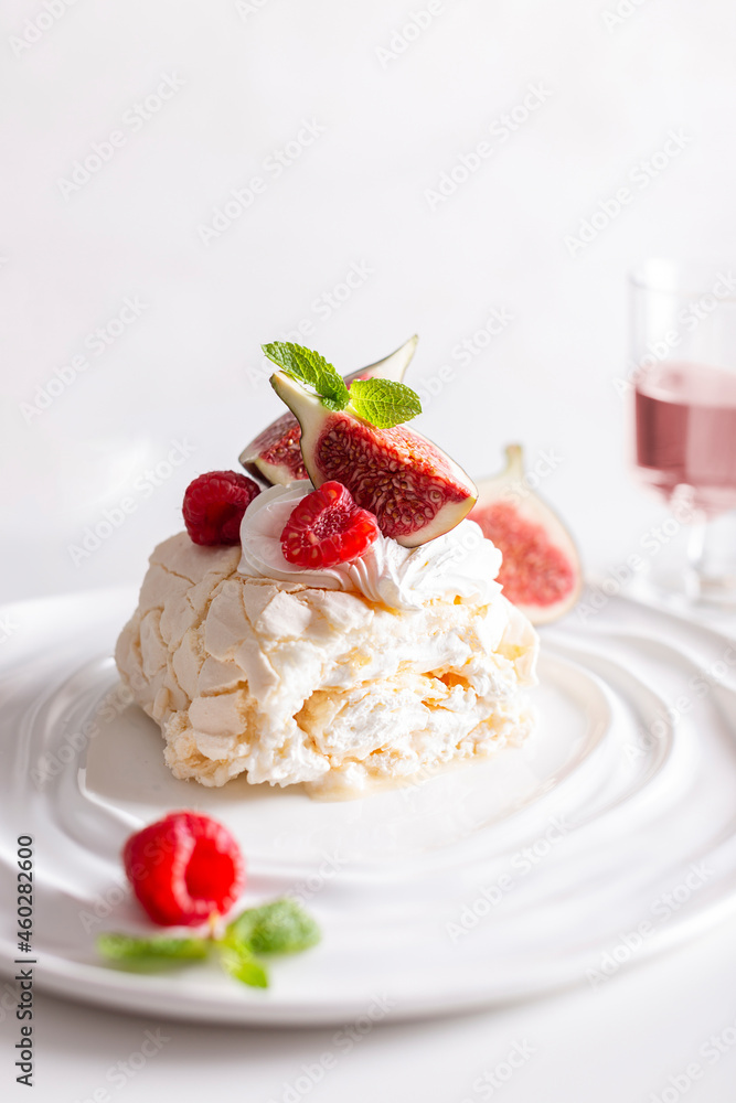 Beautiful meringue roll named Pavlova, decorated with figs and raspberries Beautiful meringue roll named Pavlova, decorated with figs and raspberries