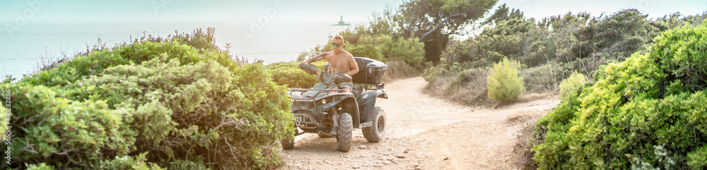 Naklejka premium lässiger Typ erkundet das Gelände auf einem Quad