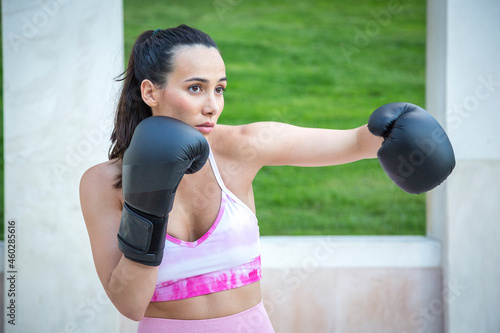 young athlete woman training boxing with gloves giving a crochet