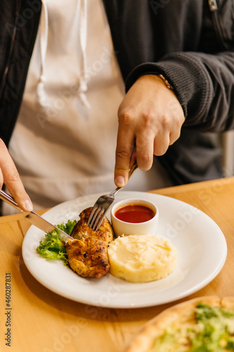 man eats potatoes with chicken steak