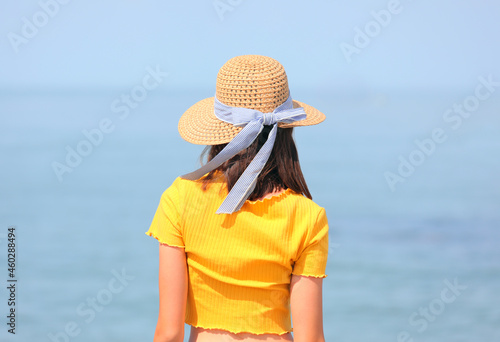 young skinny girl with straw hat and yellow t-shirt and the sea © ChiccoDodiFC