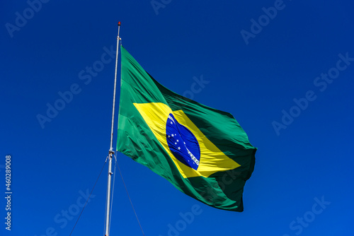 Brazilian flag hoisted with blue sky. photo
