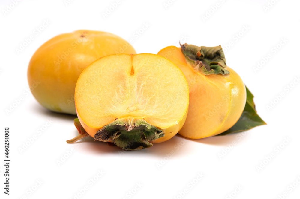 Whole and cut in half of persimmon with leaves isolated on white background.