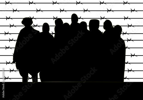 Silueta negra de prisioneros tras la alambrada de pinchos en un campo de concentración. Refugiados photo