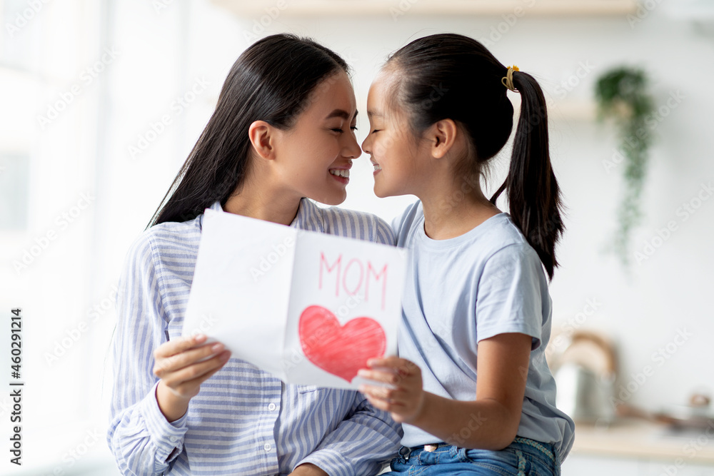 Family love. Happy asian girl hugging her mother and greeting with Mother's day, young woman holding handcraft present Family love. Happy asian girl hugging her mother and greeting with Mother's day, young woman holding handcraft present