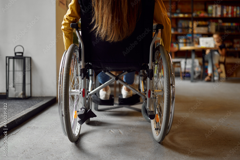 Disabled female student in wheelchair, back view