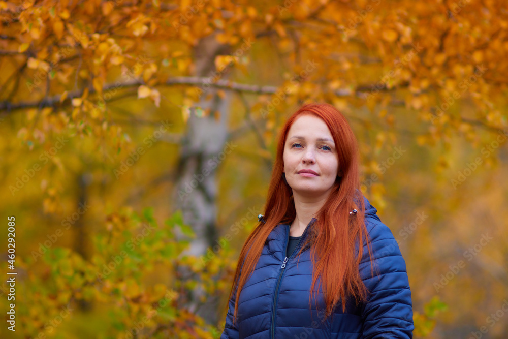 portrait of a life style woman with red hair in autumn against a background of colorful foliage portrait of a life style woman with red hair in autumn against a background of colorful foliage