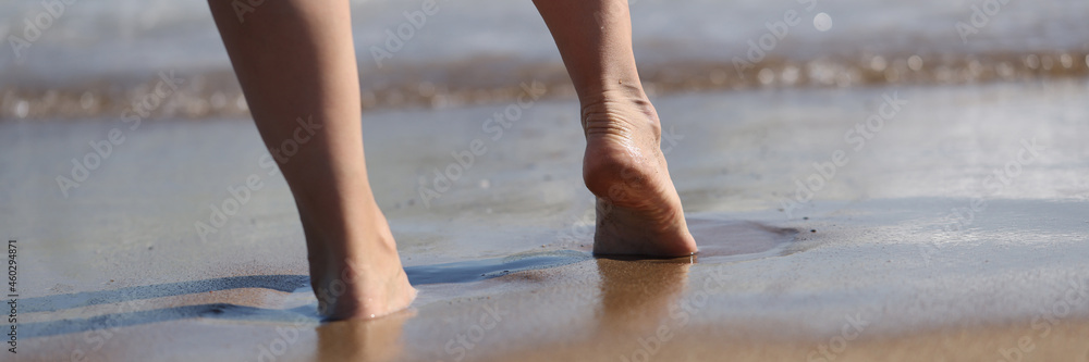 Woman goes to sea, part of body enjoying time on beach Woman goes to sea, part of body enjoying time on beach