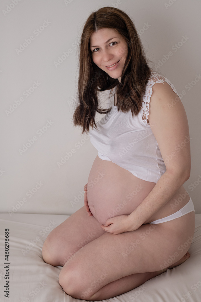 Mujer embarazada sonriendo mostrando su panza Mujer embarazada sonriendo mostrando su panza