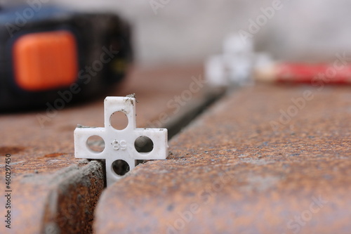 White plastic crosses in the joints between clinker tiles