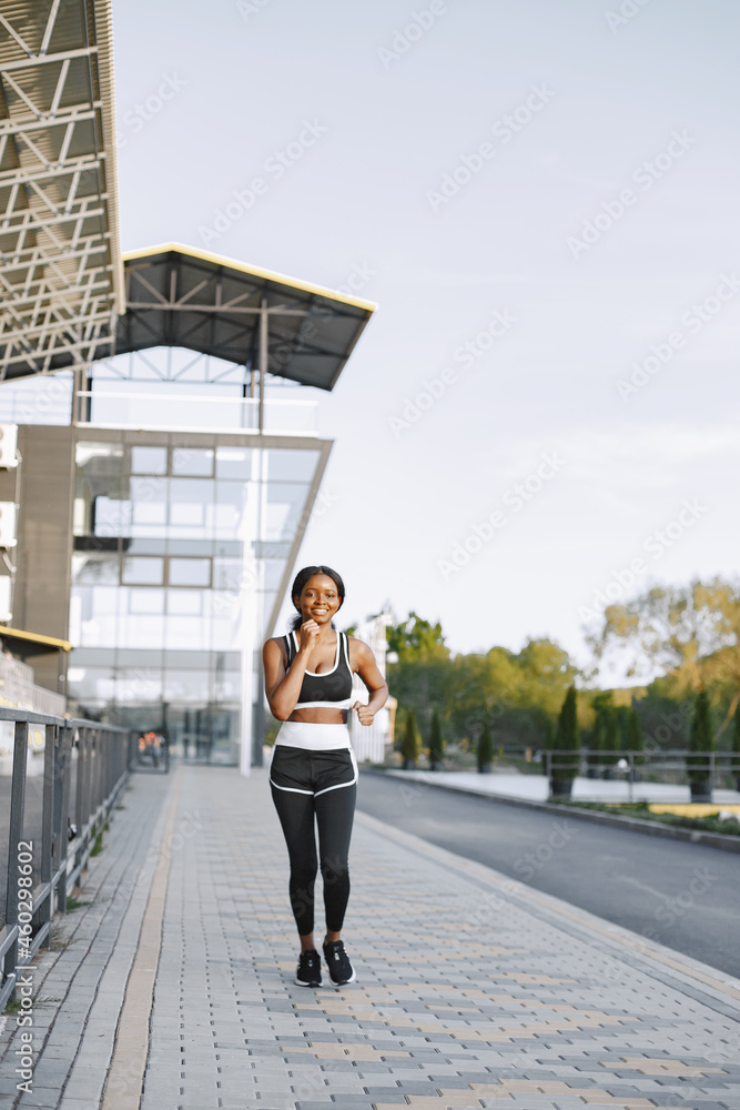 Portrait of a young fit african-american woman jogging outdoors