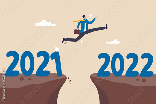 Year 2022 hope, new year resolution or success opportunity, change to new business bright future, overcome business difficulty concept, ambitious businessman jump over year gap from 2021 to 2022.