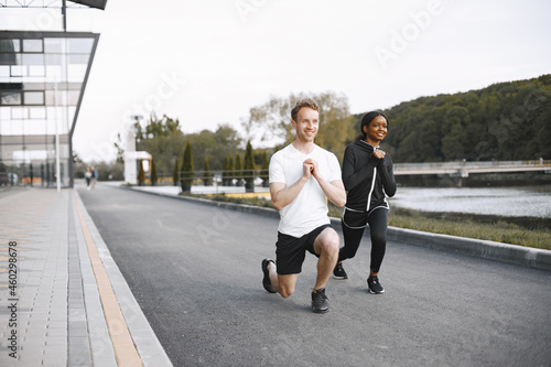 African-american woman and caucasian man training at the stadium