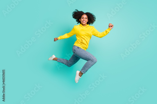 Full length body size view of attractuve cheerful girl jumping running good mood isolated over bright teal turquoise color background photo