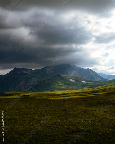 Beautiful photography of the mountain Oshten. Dramatic sky in the background and sun rays. Idea of tourism and hiking, breathtaking nature. High mountain in Russia.