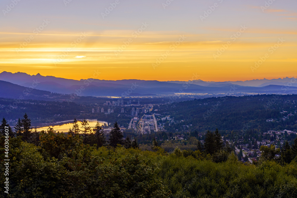 Golden sunrise over Fraser Valley reflected in Burrard Inlet at Port Moody, BC
