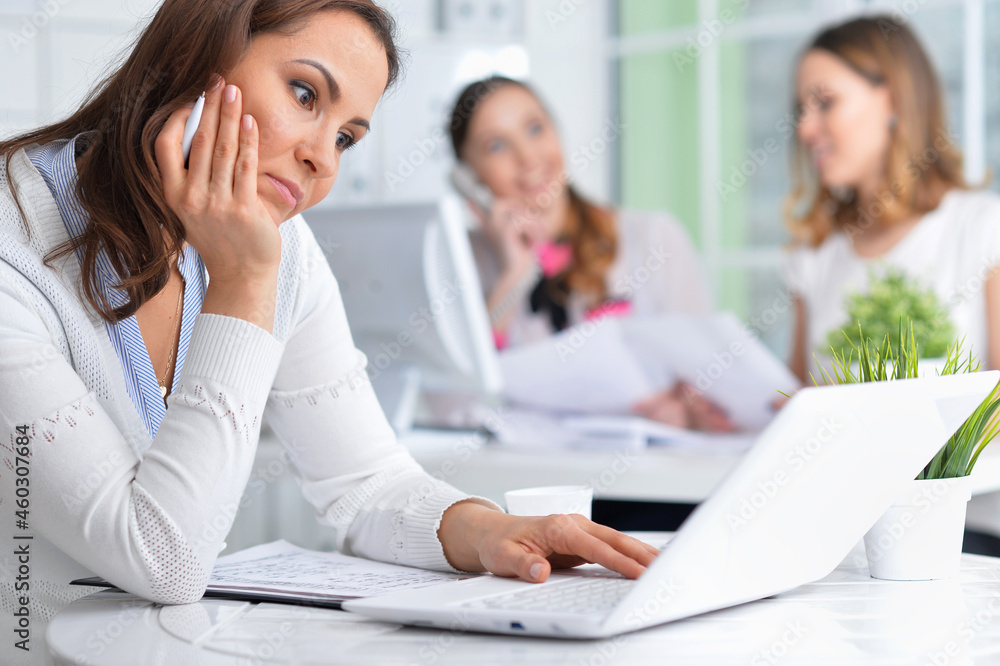 young women sit at the table and work in a modern office young women sit at the table and work in a modern office