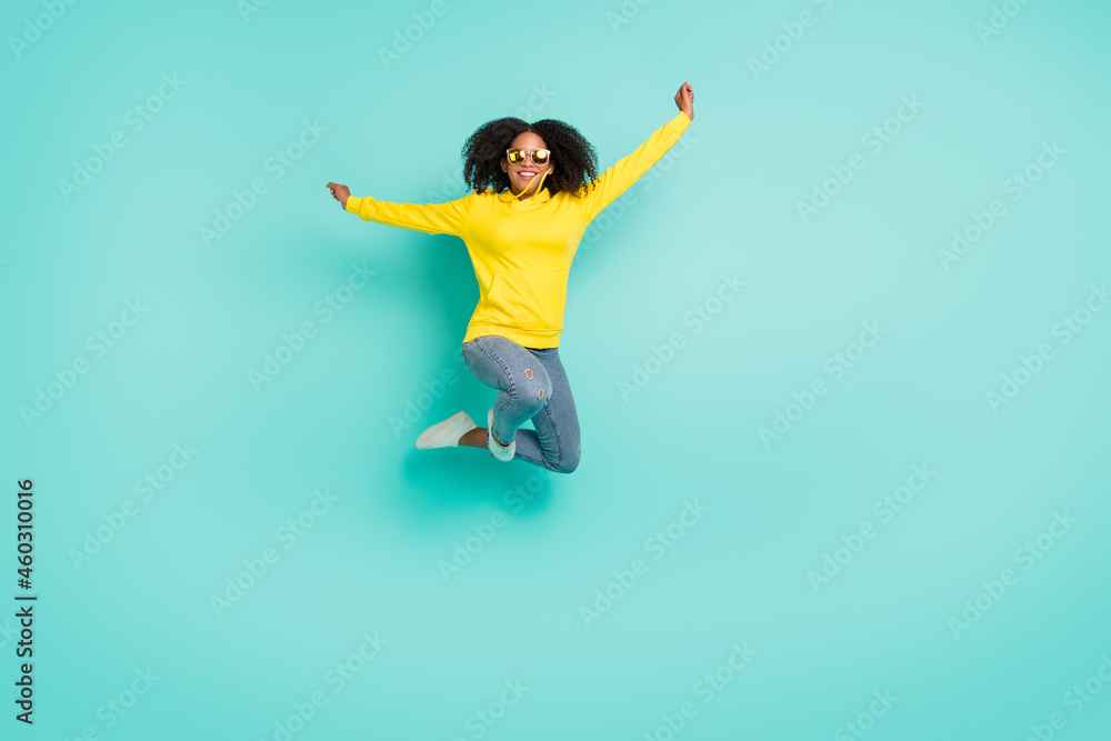 Full length body size view of nice cheerful wavy-haired girl jumping having fun isolated over bright teal turquoise color background