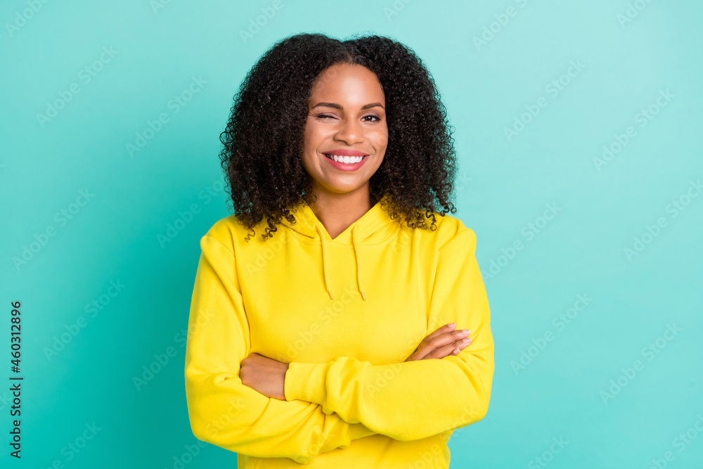 Obraz premium Photo portrait woman smiling confident crossed hands winking isolated vivid teal color background