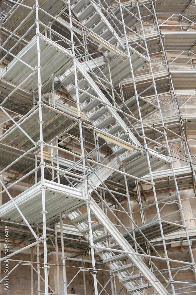 Multi-storey scaffolding with a vertical staircase near the old building