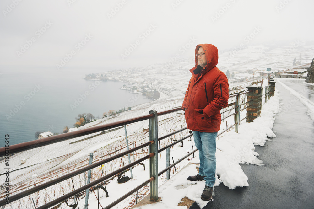 Outdoor portrait of middle age man enjoying winter landscape of snowy vinyards
