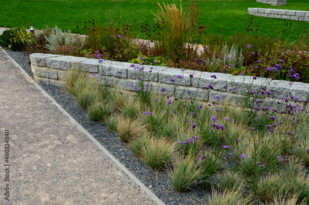 Granite walls made of stone blocks serve as design elements, retaining walls, or seating areas, seats for park visitors. parking for bicycles with metal frames and benches made of horizontal wires