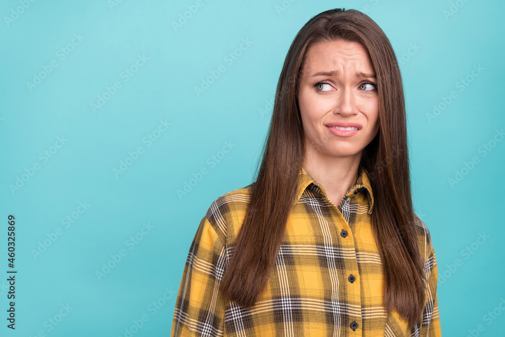Portrait of attractive unsatisfied young lady look empty space grin teeth isolated on blue color background Portrait of attractive unsatisfied young lady look empty space grin teeth isolated on blue color background