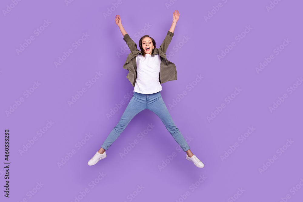 Full length body size photo woman jumping high overjoyed isolated pastel purple color background Full length body size photo woman jumping high overjoyed isolated pastel purple color background