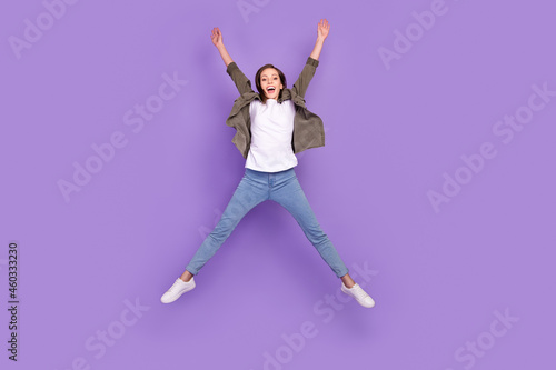 Full length body size photo woman jumping high overjoyed isolated pastel purple color background © deagreez